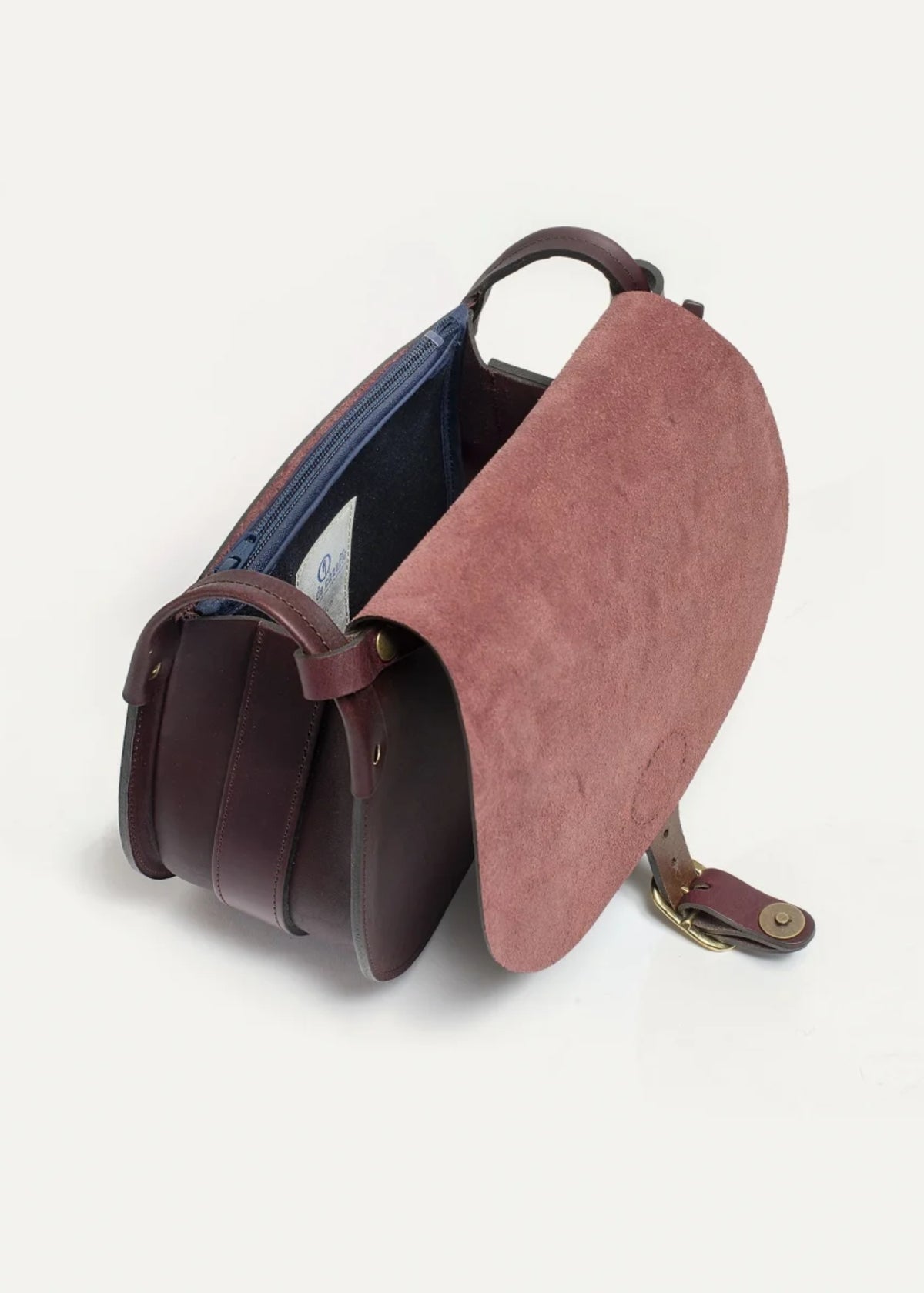 A structured leather shoulder bag in dark brown and dusty rose pink, shown open to reveal a blue interior lining, on a light gray background.